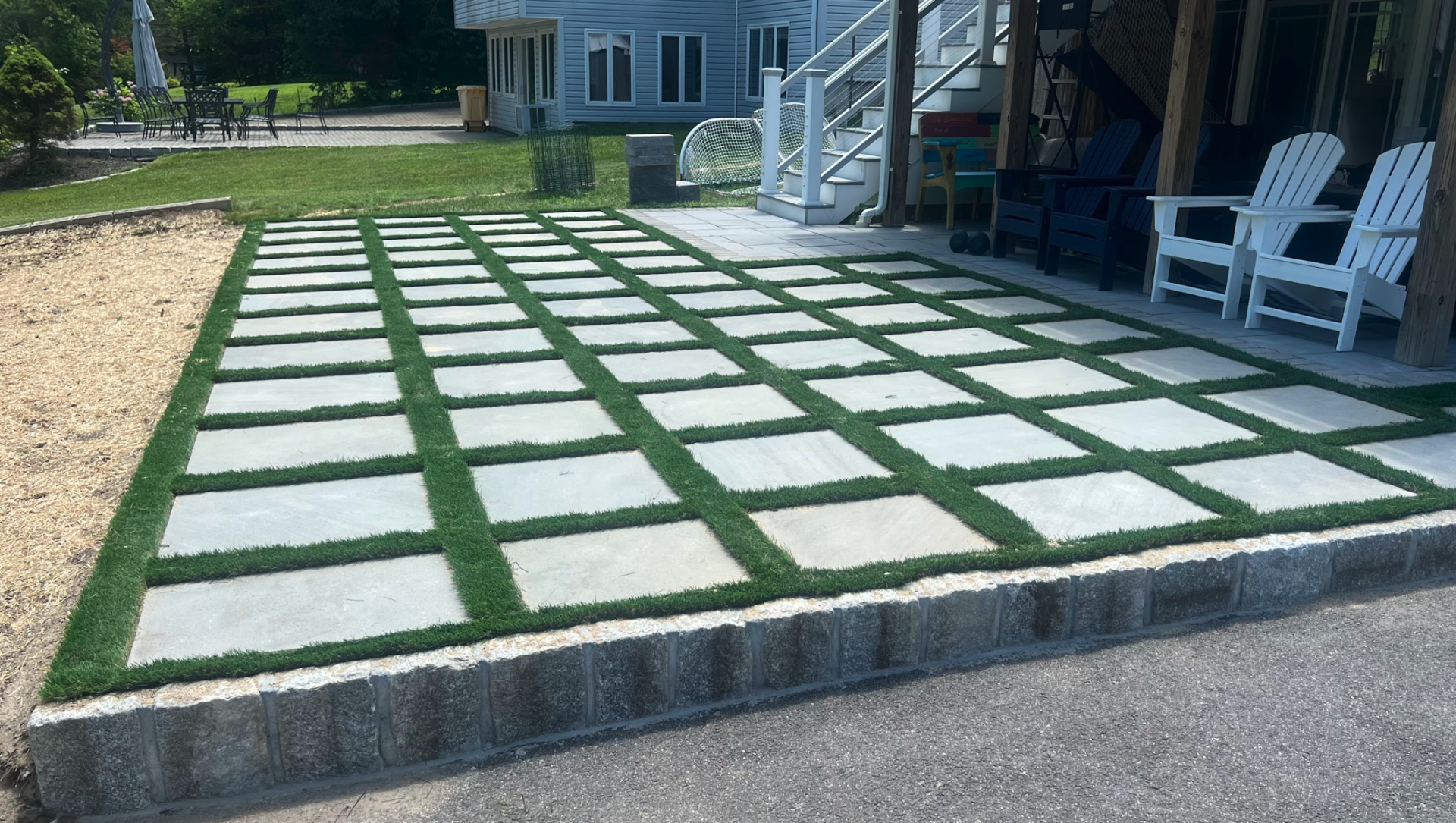 Modern grid-style paver patio with concrete slabs and turf joints creating a contemporary outdoor living space